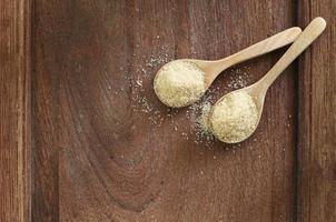 Top view two spoons of brown sweet  sugar  on wooden table with copy space. photo