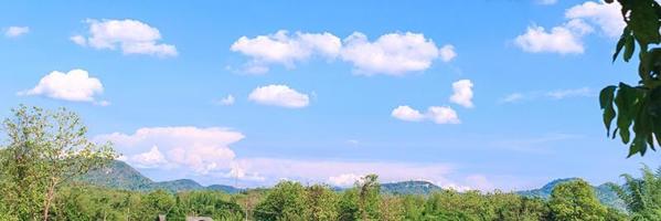 blue sky with white clouds in the daytime , mountains and forests photo
