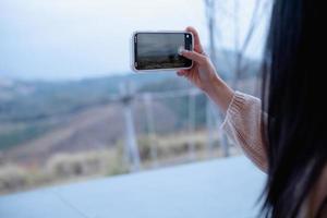 mujer que usa un teléfono inteligente toma una foto en khao kho, tailandia