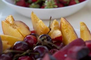 Fresh fruit on a plate on a white table photo