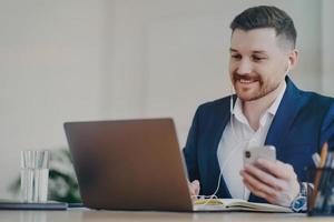 Happy businessman having video conference call while working at office photo