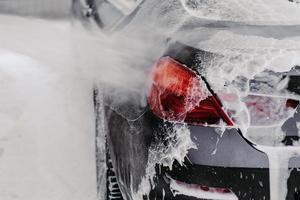 Car washing concept. Auto cleaning with high pressure of water. Contactless self service car wash. Close up shot. Selective focus. photo