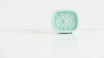 Blue table clock with arrows on a white table photo