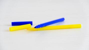 Blue and yellow felt-tip pens on a white background photo