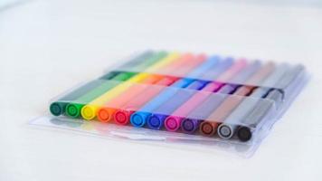 Multicolored felt-tip pens in a transparent package on a white background photo