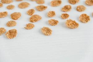 Crispy healthy dry cereal flakes on white background photo