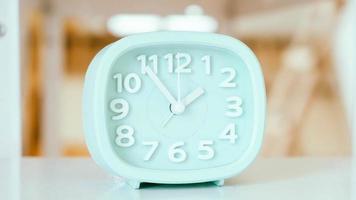 Blue table clock with arrows on a white table photo