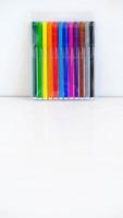 Multicolored felt-tip pens in a transparent package on a white background photo