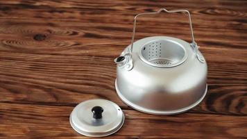 Metal kettle for hiking on a wooden table background photo