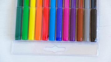 Multicolored felt-tip pens in a transparent package on a white background photo