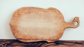 Wooden cutting board on brown table background photo