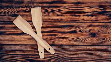 Wooden kitchen spatulas on brown table background photo