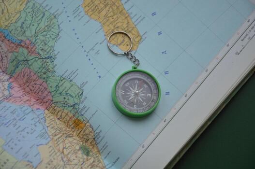 Hand compass for travel on the background of objects photo