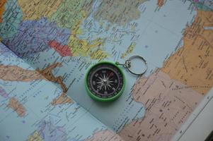 Hand compass for travel on the background of objects photo