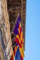 Low angle view of flags on beautiful historic building against clear blue sky photo