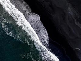 islandia playa de arena negra con enormes olas en reynisfjara vik. foto