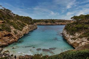 vista de ángulo alto de los turistas disfrutando en el acantilado en la isla contra el cielo azul foto