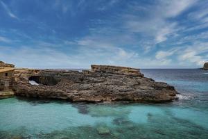 vista idílica del acantilado rocoso en el hermoso océano azul en la isla contra el cielo foto