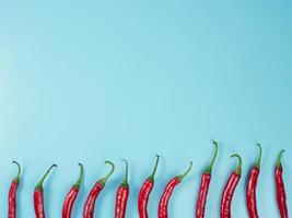 Chili peppers isolated on blue background. Red hot chili peppers as an ingredient of Asian and Mexican cuisine and spices photo