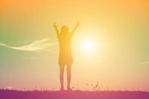 Silhouette of woman praying over beautiful sky background photo