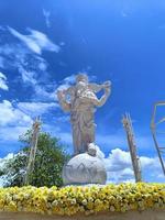 estatua de ganesha y textura blanca con flores, ganesha es el dios hindú del éxito. foto