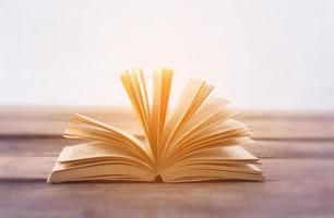 Open book on wood planks over abstract light background photo