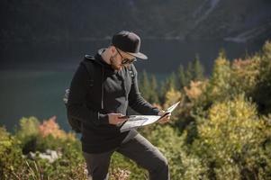 Young man traveler with map and backpack photo