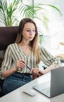 mujer joven trabajando en una computadora foto