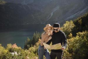 Young tourist couple, man and woman, on hiking path in mountains photo