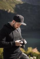 joven fotógrafo tomando fotografías con cámara digital en una montaña. foto