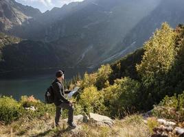 Young man traveler with map and backpack photo