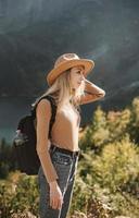 Woman traveler wearing hat and looking at amazing mountains and lake photo