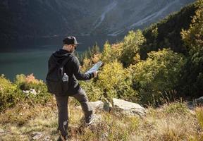 Young man traveler with map and backpack photo
