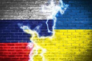 bandera de ucrania y rusia en la pared de ladrillo relaciones diplomáticas entre ucrania y rusia. bandera de los dos países concepto ucrania rusia conflicto foto