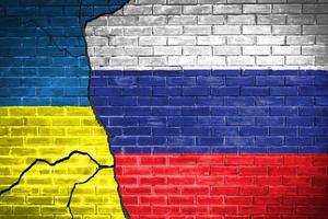 bandera de ucrania y rusia en la pared de ladrillo relaciones diplomáticas entre ucrania y rusia. bandera de los dos países concepto ucrania rusia conflicto foto