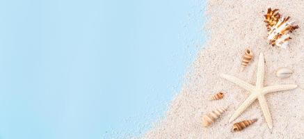 Top view with copy space of sand with starfish and shells on blue background. photo