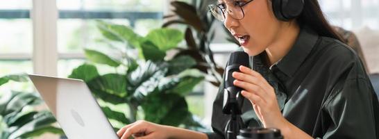 Woman use microphones wear headphones with laptop record podcast. Content creator concept. photo