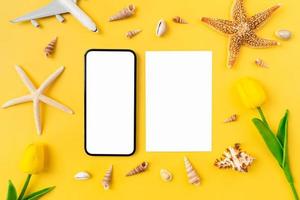 Summer time concept, Smartphone mockup screen with blank paper for advertising signs and beach accessories on the yellow background. photo