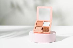 Face Powder or Eyeshadow container as decorative cosmetics on podium. photo