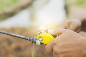 Hand holding a fishing rod photo