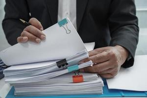 Businessman working and prepare paperwork report data to analysis information in file binder at office. photo
