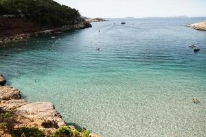 hermosa playa con agua muy limpia y azul en el mar mediterráneo en la isla de ibiza, españa foto