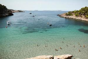 hermosa playa con agua muy limpia y azul en el mar mediterráneo en la isla de ibiza, españa foto