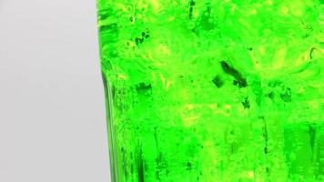 Pouring Green sparkling water with ice cubes close-up. video