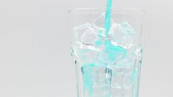 Pouring Blue Hawaii sparkling water with ice cubes close-up. video