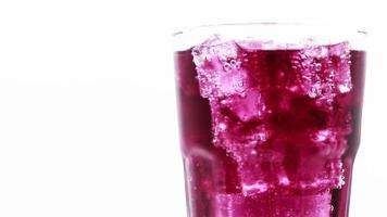Grape sparkling water with Ice in glass over white background. video