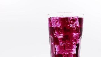 Grape sparkling water with Ice in glass over white background. video