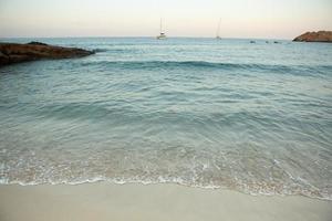 hermosa playa con agua muy limpia y azul en el mar mediterráneo en la isla de ibiza, españa. foto