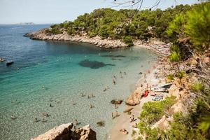 hermosa playa con agua muy limpia y azul en el mar mediterráneo en la isla de ibiza, españa foto