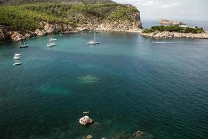 hermosa playa con agua muy limpia y azul en el mar mediterráneo en la isla de ibiza, españa foto